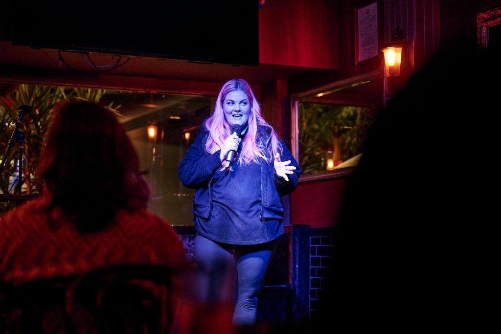 Empowered Electrical owner, and part-time comedian, Caitlin Maggs performing during an open mic night at the Durham in Kingston. 11 May 2023