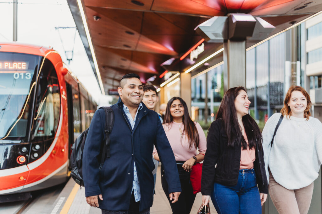 Group of students walking at a light rail station 